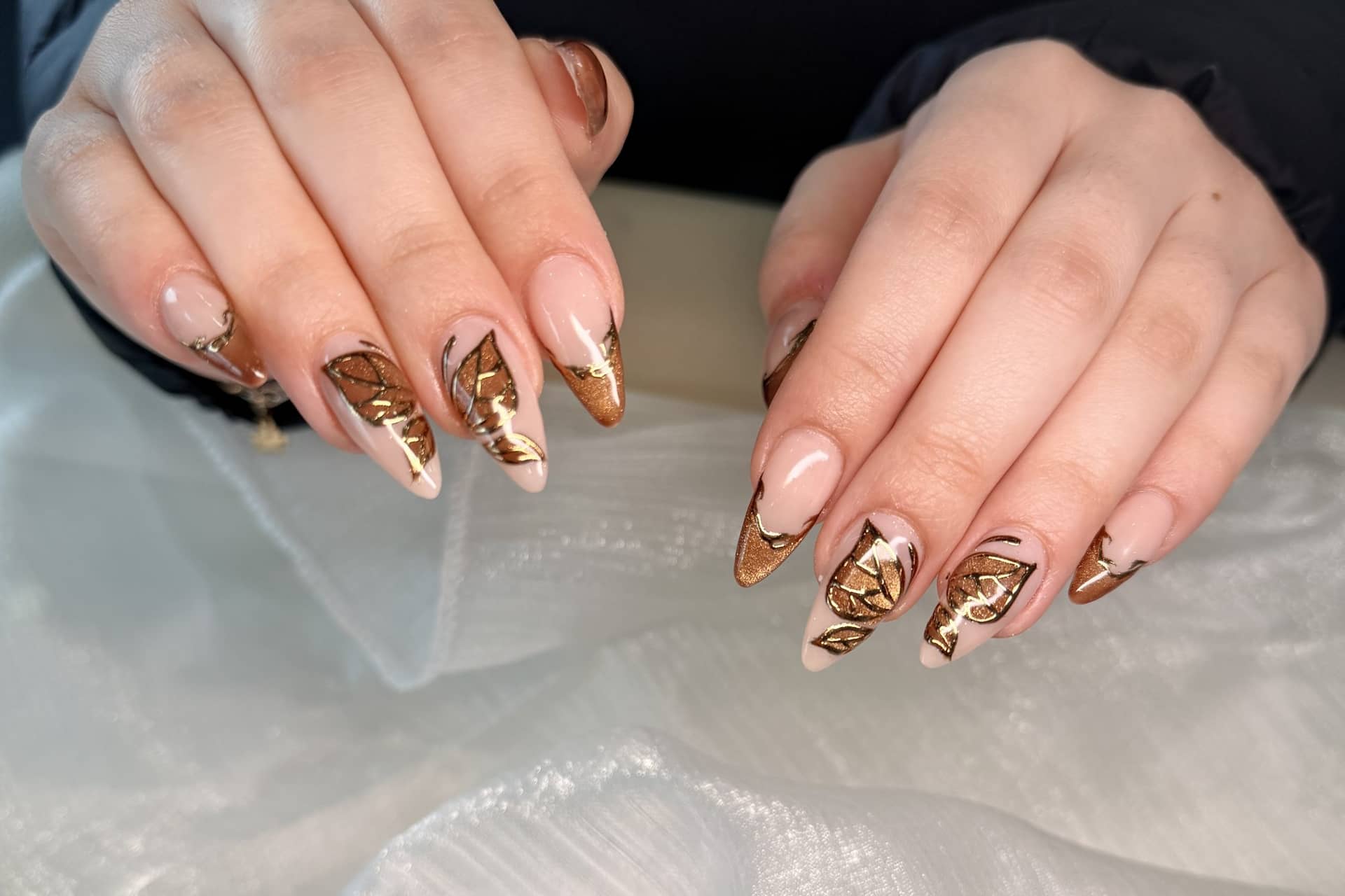 Gold-leaf French tips on almond nails, fresh at the desk